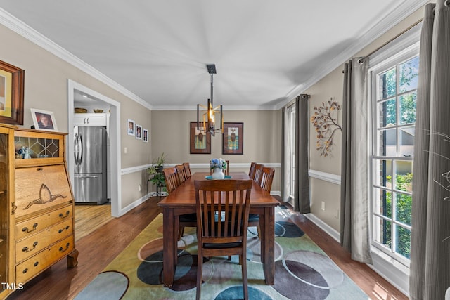 2901 Ceremonial Ct, Raleigh, NC 27615 - dining area with wood finished floors, a chandelier, ornamental molding, and baseboards
