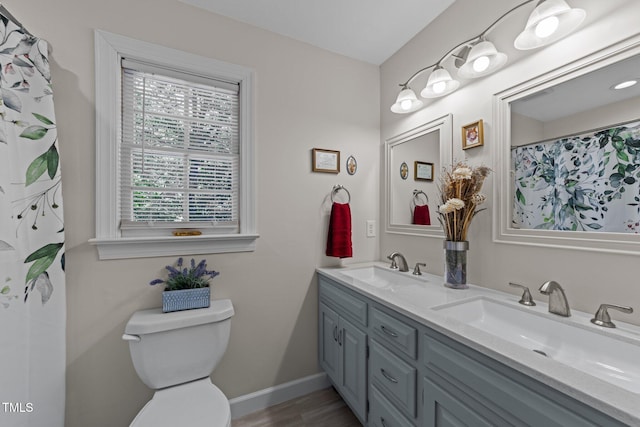 2901 Ceremonial Ct, Raleigh, NC 27615 - full bath featuring double vanity, toilet, baseboards, and wood finished floors