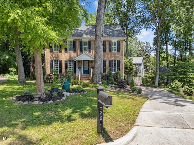 2901 Ceremonial Ct, Raleigh, NC 27615 - colonial inspired home featuring brick siding, a front lawn, and concrete driveway