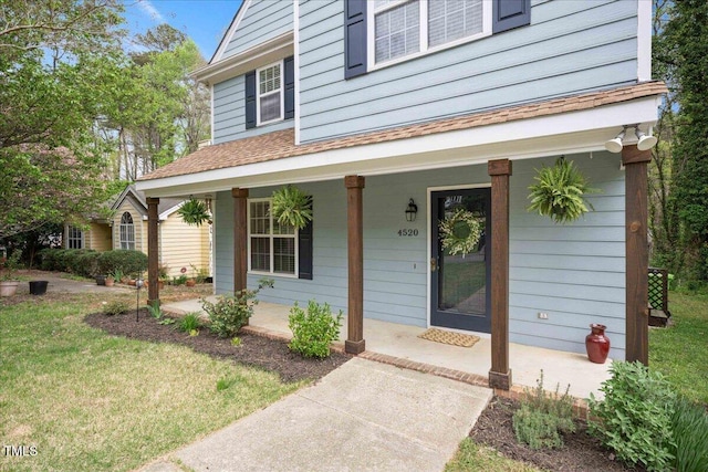 4520 Timberhurst Dr, Raleigh, NC 27612 - doorway to property featuring a porch, a shingled roof, and a yard
