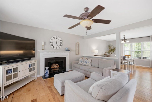 4520 Timberhurst Dr, Raleigh, NC 27612 - living room featuring light wood-style flooring, a fireplace with flush hearth, a ceiling fan, and baseboards