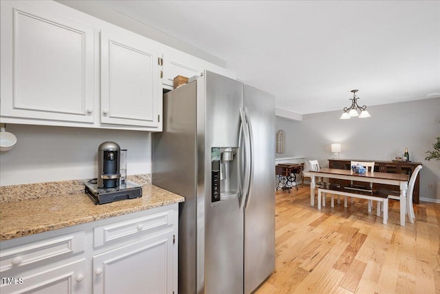 4520 Timberhurst Dr, Raleigh, NC 27612 - kitchen with stainless steel refrigerator with ice dispenser, light wood-type flooring, white cabinetry, a chandelier, and light stone countertops