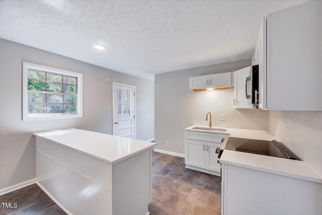 8004 Summit Dr, Goldsboro, NC 27530 - kitchen with a sink, white cabinetry, light countertops, a textured ceiling, and baseboards