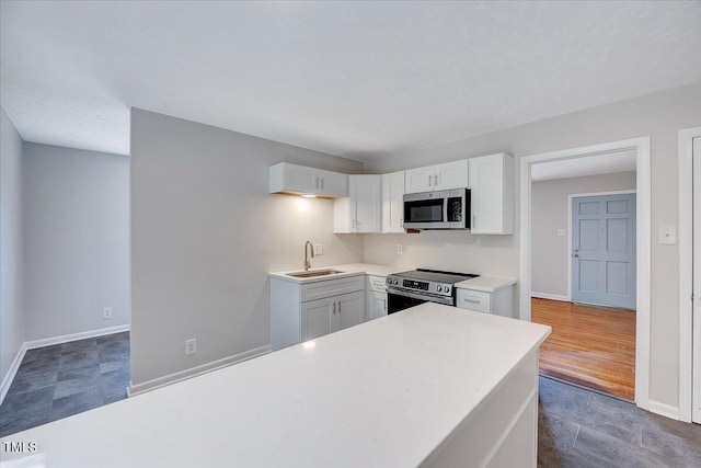 8004 Summit Dr, Goldsboro, NC 27530 - kitchen featuring appliances with stainless steel finishes, a sink, light countertops, white cabinets, and baseboards