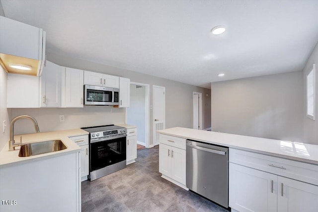 8004 Summit Dr, Goldsboro, NC 27530 - kitchen with stainless steel appliances, a sink, white cabinets, light countertops, and recessed lighting