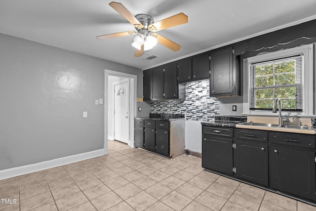 1818 Cecil St, Durham, NC 27707 - kitchen with a ceiling fan, dark cabinetry, backsplash, and light tile patterned flooring
