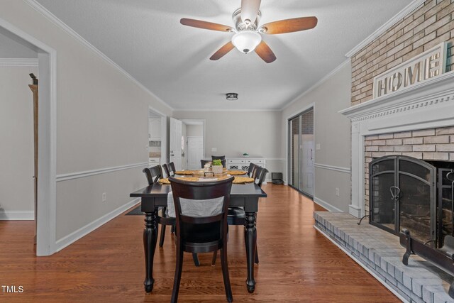 815 Walter Bright Rd, Sanford, NC 27330 - dining space featuring a fireplace, ceiling fan, ornamental molding, baseboards, and wood finished floors