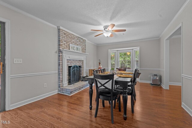 815 Walter Bright Rd, Sanford, NC 27330 - dining space featuring a fireplace, a ceiling fan, wood finished floors, baseboards, and crown molding