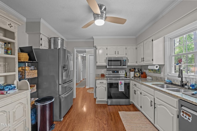 815 Walter Bright Rd, Sanford, NC 27330 - kitchen with appliances with stainless steel finishes, a sink, light wood finished floors, a ceiling fan, and white cabinets