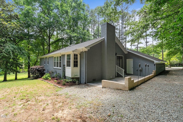815 Walter Bright Rd, Sanford, NC 27330 - view of side of property with brick siding, a chimney, view of scattered trees, and a patio