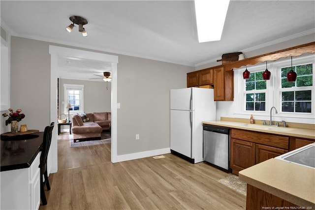4101 Vann Dr, Lumberton, NC 28358 - kitchen featuring stainless steel dishwasher, freestanding refrigerator, a sink, brown cabinetry, and ornamental molding
