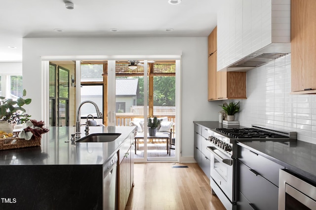 1405 Watts St, Durham, NC 27701 - kitchen with stainless steel appliances, a sink, wall chimney range hood, ceiling fan, and healthy amount of natural light