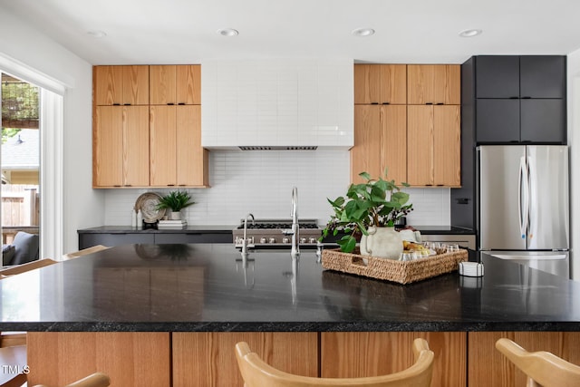 1405 Watts St, Durham, NC 27701 - kitchen featuring freestanding refrigerator, an island with sink, decorative backsplash, a kitchen bar, and recessed lighting