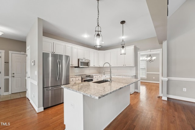 105 Bagley Ln, Dunn, NC 28334 - kitchen featuring stainless steel appliances, a sink, white cabinetry, wood finished floors, and recessed lighting