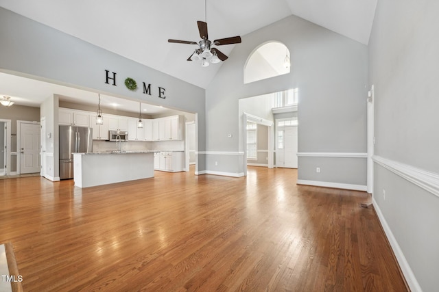 105 Bagley Ln, Dunn, NC 28334 - unfurnished living room with a ceiling fan, high vaulted ceiling, light wood-type flooring, and baseboards