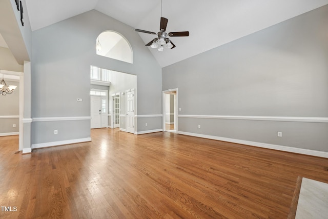 105 Bagley Ln, Dunn, NC 28334 - unfurnished living room with high vaulted ceiling, a ceiling fan, a chandelier, wood finished floors, and baseboards