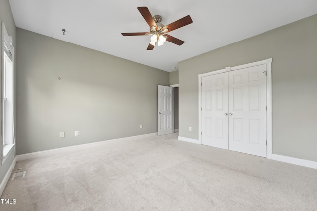 105 Bagley Ln, Dunn, NC 28334 - unfurnished bedroom featuring light colored carpet, a closet, baseboards, and a ceiling fan