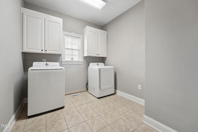 105 Bagley Ln, Dunn, NC 28334 - laundry area featuring separate washer and dryer, cabinet space, baseboards, and light tile patterned floors