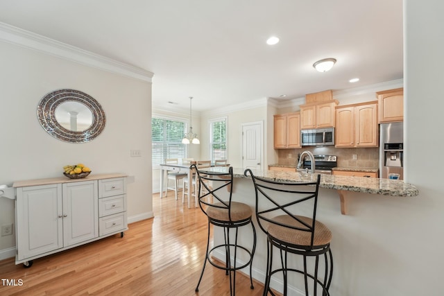 105 Old Barn Way, Wendell, NC 27591 - kitchen featuring appliances with stainless steel finishes, a breakfast bar, crown molding, light wood-style floors, and light brown cabinets