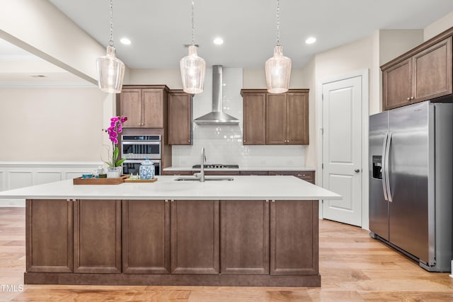 192 Glenpark Pl, Cary, NC 27511 - kitchen with stainless steel appliances, wall chimney exhaust hood, a sink, an island with sink, and light countertops