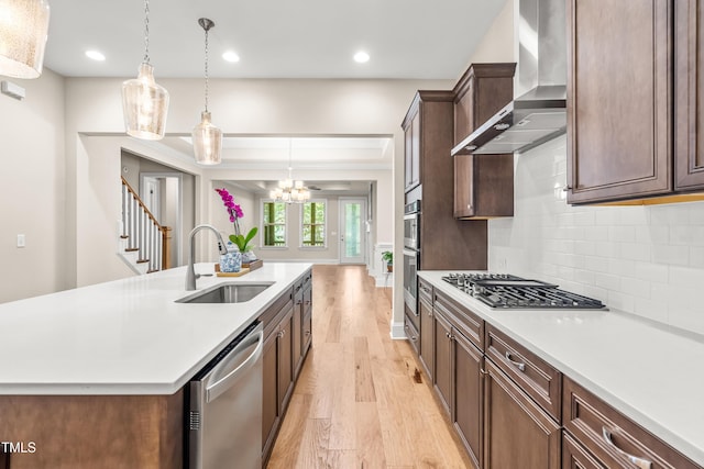 192 Glenpark Pl, Cary, NC 27511 - kitchen featuring wall chimney range hood, stainless steel appliances, a sink, light wood finished floors, and light countertops