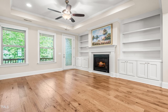 192 Glenpark Pl, Cary, NC 27511 - unfurnished living room featuring light wood-type flooring, a ceiling fan, crown molding, a glass covered fireplace, and baseboards