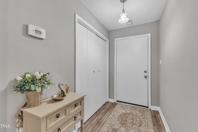 501 Gooseneck Dr Unit B2, Cary, NC 27513 - entryway with light wood-style floors, a textured ceiling, and baseboards