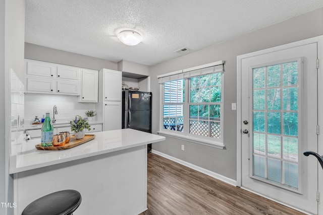 501 Gooseneck Dr Unit B2, Cary, NC 27513 - kitchen with a textured ceiling, dark wood finished floors, white cabinets, a peninsula, and backsplash
