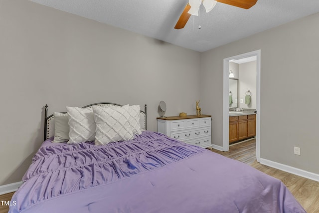 501 Gooseneck Dr Unit B2, Cary, NC 27513 - bedroom featuring light wood-style floors, baseboards, connected bathroom, a textured ceiling, and a ceiling fan