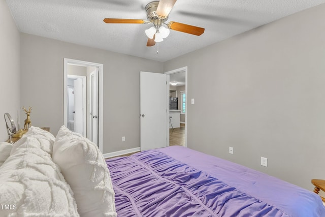 501 Gooseneck Dr Unit B2, Cary, NC 27513 - bedroom with baseboards, ceiling fan, connected bathroom, and a textured ceiling