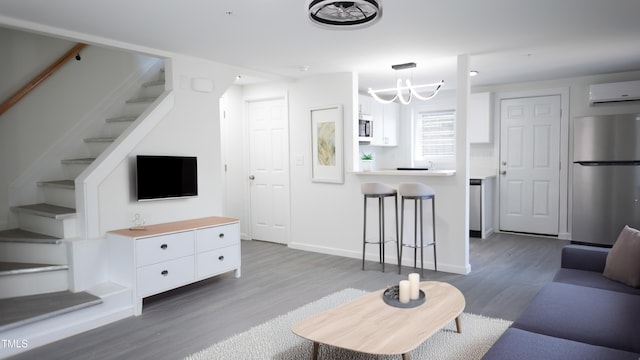 800 Pritchard Avenue Extension Unit H4, Chapel Hill, NC 27516 - living area with a wall unit AC, stairs, wood finished floors, a chandelier, and baseboards