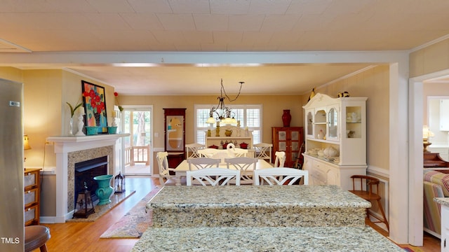 4509 Stevens Chapel Rd, Smithfield, NC 27577 - dining room with crown molding, light wood-style floors, and a fireplace with raised hearth