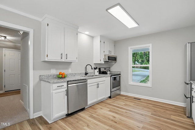 3916 W Allen, Raleigh, NC 27603 - kitchen featuring stainless steel appliances, a sink, baseboards, light wood-type flooring, and white cabinets