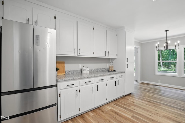 3916 W Allen, Raleigh, NC 27603 - kitchen featuring freestanding refrigerator, white cabinetry, ornamental molding, and a chandelier