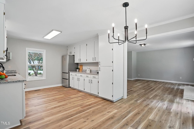 3916 W Allen, Raleigh, NC 27603 - kitchen with freestanding refrigerator, a chandelier, light wood-style floors, and white cabinets