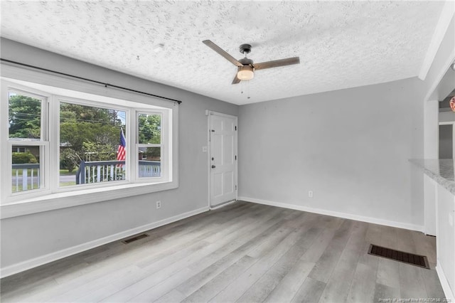 5409 S Sumac Cir, Fayetteville, NC 28304 - unfurnished living room featuring a ceiling fan, wood finished floors, a textured ceiling, and baseboards