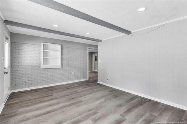 5409 S Sumac Cir, Fayetteville, NC 28304 - unfurnished room with brick wall, wood finished floors, baseboards, recessed lighting, and beam ceiling
