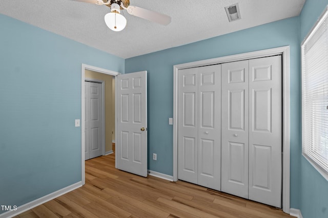 5134 Greenville Loop Rd Apt D, Wilmington, NC 28409 - unfurnished bedroom featuring baseboards, wood finished floors, multiple windows, and a textured ceiling
