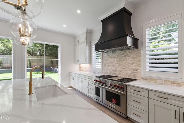 2805 Van Dyke Ave, Raleigh, NC 27607 - kitchen featuring range with two ovens, custom range hood, ornamental molding, a sink, and healthy amount of natural light
