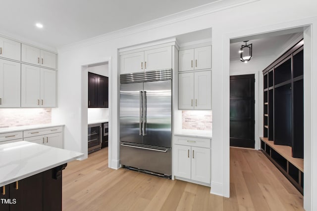 2805 Van Dyke Ave, Raleigh, NC 27607 - kitchen featuring stainless steel built in refrigerator, crown molding, light wood finished floors, decorative backsplash, and wine cooler