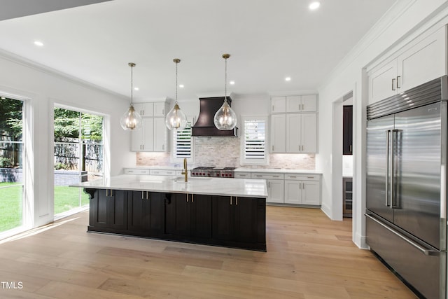 2805 Van Dyke Ave, Raleigh, NC 27607 - kitchen featuring high quality fridge, custom range hood, white cabinetry, ornamental molding, and light wood-style flooring