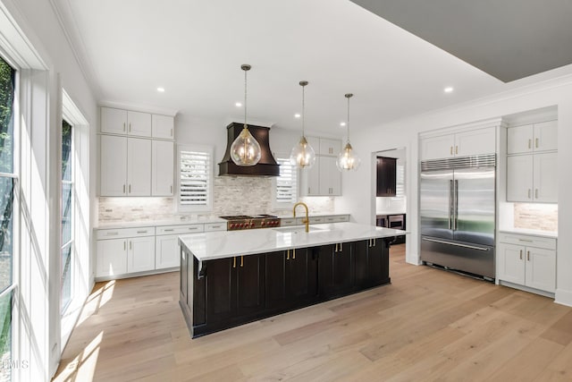 2805 Van Dyke Ave, Raleigh, NC 27607 - kitchen with stainless steel built in fridge, custom exhaust hood, backsplash, ornamental molding, and white cabinets