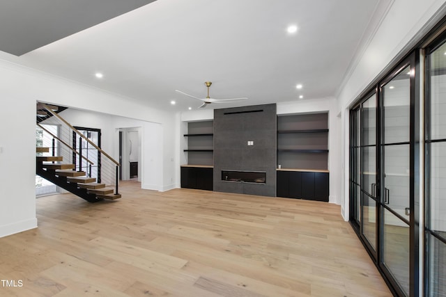 2805 Van Dyke Ave, Raleigh, NC 27607 - unfurnished living room with ornamental molding, baseboards, ceiling fan, a large fireplace, and stairs