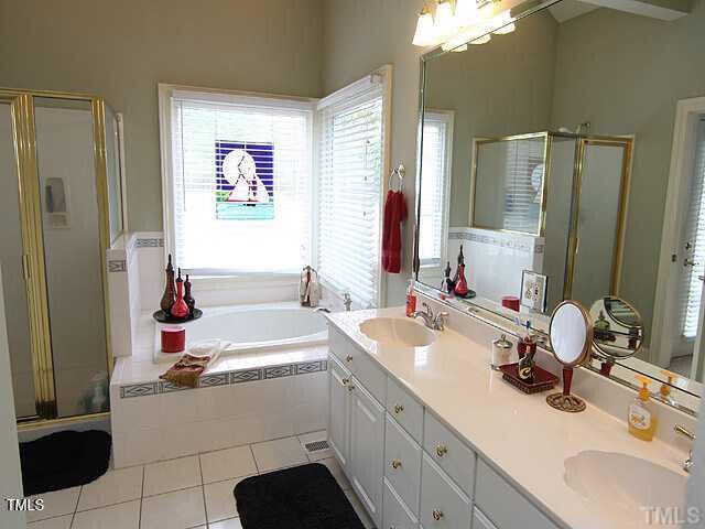 100 Lager Ln, Garner, NC 27529 - full bath featuring a shower stall, tile patterned flooring, double vanity, and a bath