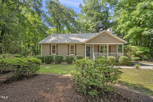 6009 Shadow Moss Cir, Raleigh, NC 27603 - view of front facade with a chimney, covered porch, a front lawn, and a shingled roof