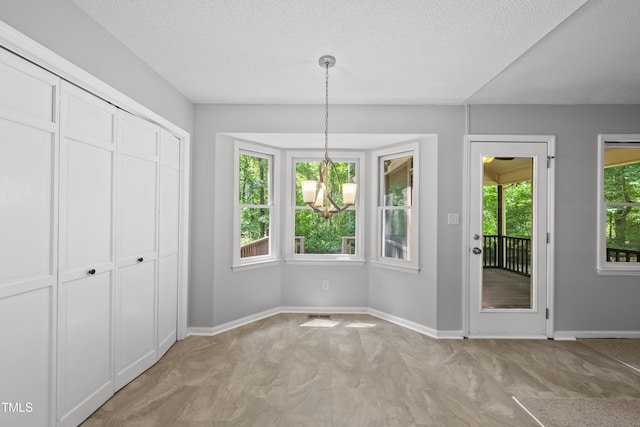 6009 Shadow Moss Cir, Raleigh, NC 27603 - unfurnished dining area with a textured ceiling, baseboards, and a chandelier