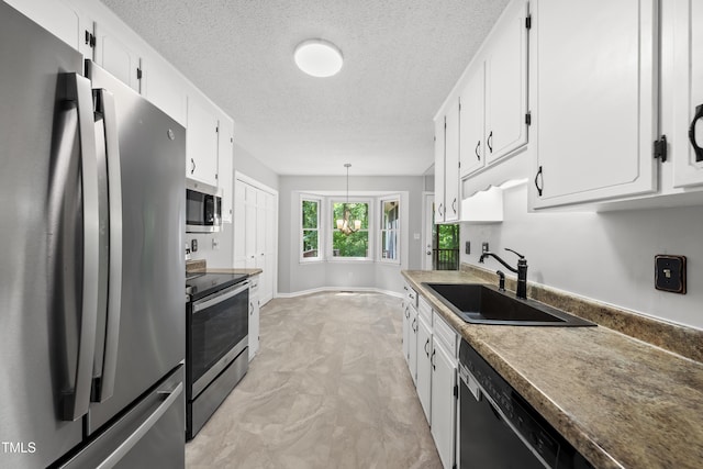 6009 Shadow Moss Cir, Raleigh, NC 27603 - kitchen with appliances with stainless steel finishes, a sink, white cabinetry, a textured ceiling, and hanging light fixtures