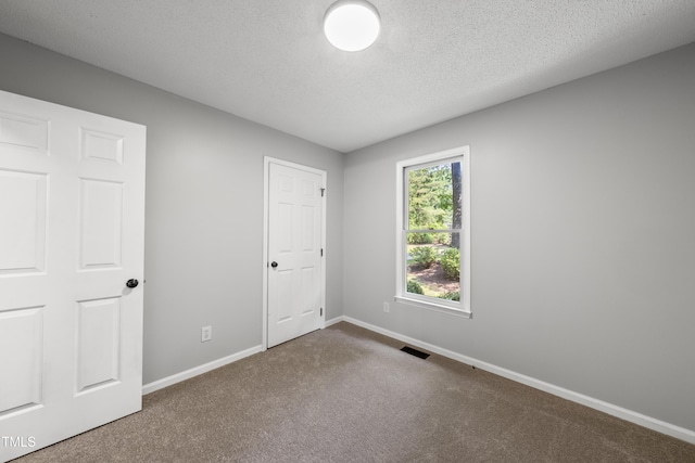 6009 Shadow Moss Cir, Raleigh, NC 27603 - unfurnished bedroom featuring carpet flooring, baseboards, and a textured ceiling