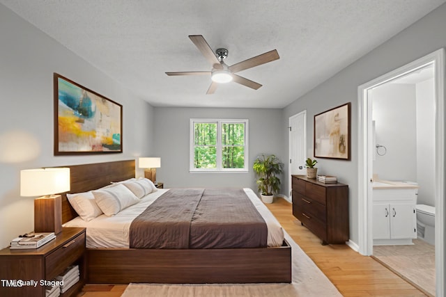 6009 Shadow Moss Cir, Raleigh, NC 27603 - bedroom with light wood-style flooring, ensuite bath, ceiling fan, and baseboards