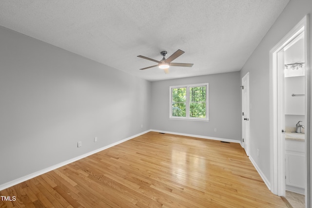 6009 Shadow Moss Cir, Raleigh, NC 27603 - empty room with ceiling fan, light wood-type flooring, baseboards, and a textured ceiling